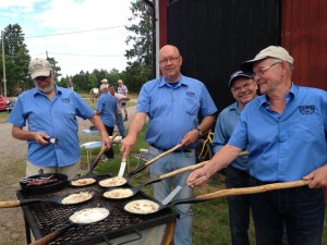 Fyra personer i blå skjortor som gräddar kolbullar